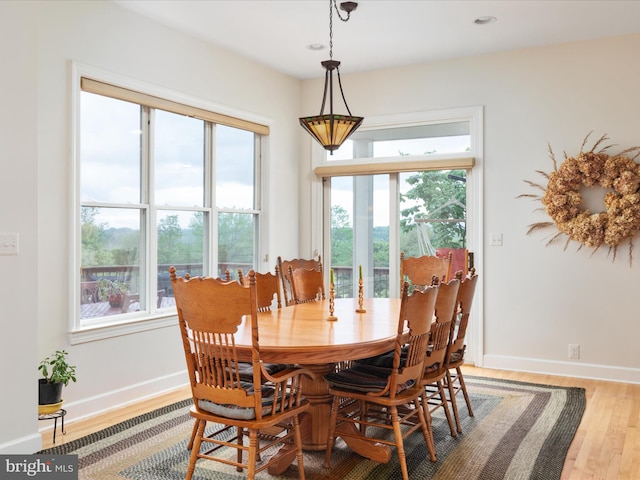 dining area featuring light wood finished floors, baseboards, and recessed lighting