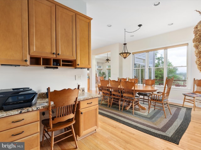 kitchen with light wood-style flooring, light stone countertops, open shelves, ceiling fan, and pendant lighting