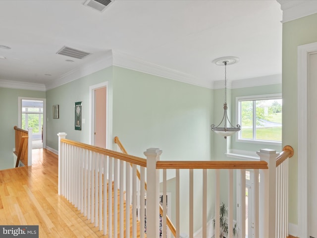 corridor featuring an upstairs landing, crown molding, wood finished floors, and baseboards