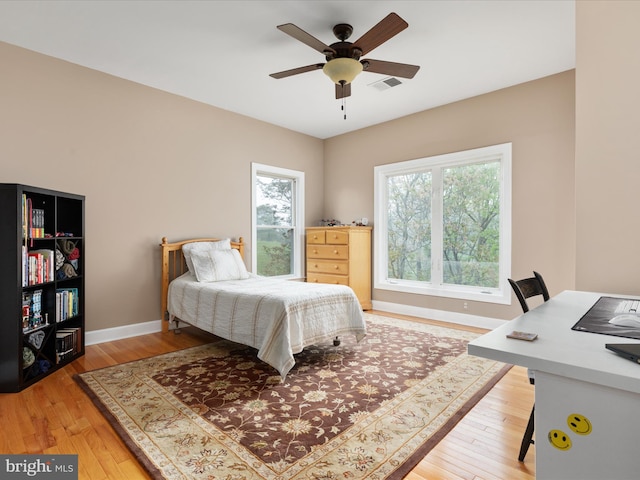 bedroom featuring light wood-type flooring, baseboards, and a ceiling fan