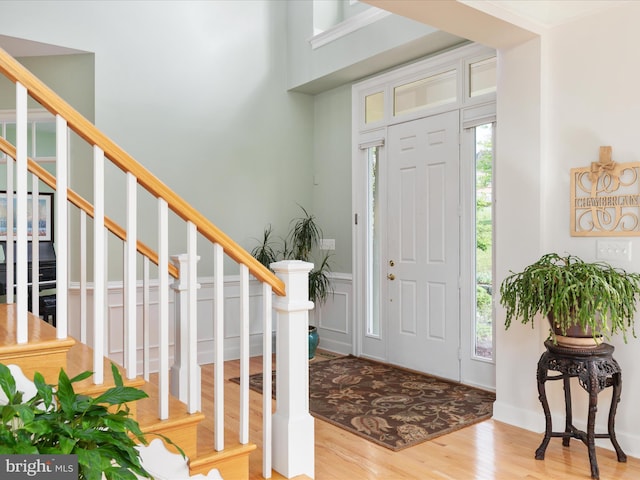 entrance foyer with wood finished floors, healthy amount of natural light, and stairs