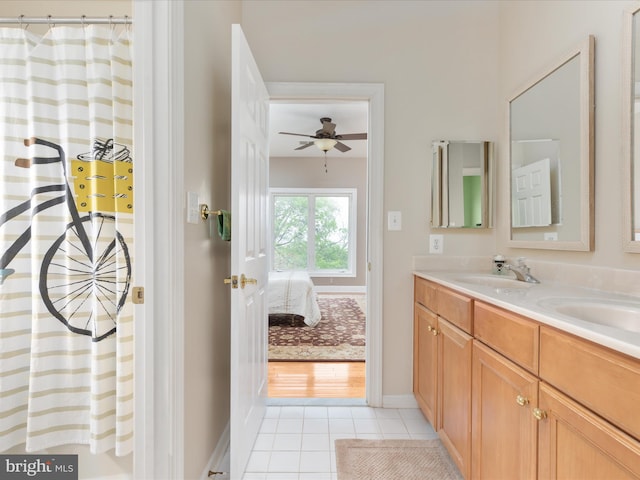 ensuite bathroom with tile patterned flooring, double vanity, baseboards, a ceiling fan, and a shower with shower curtain