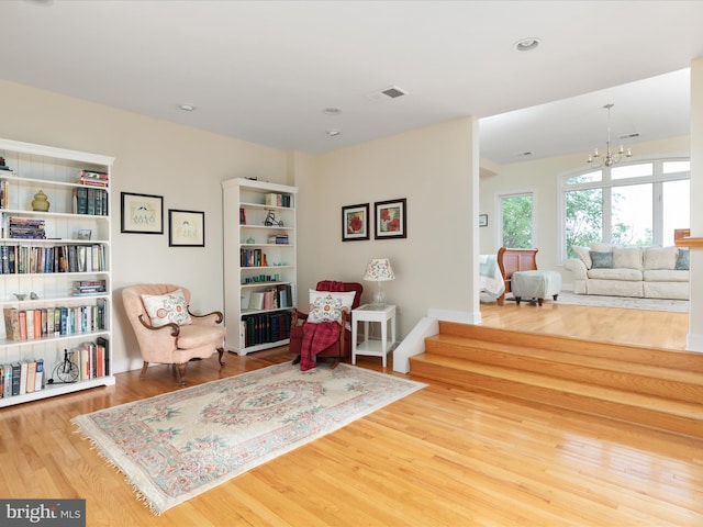 sitting room with wood finished floors, a chandelier, and recessed lighting