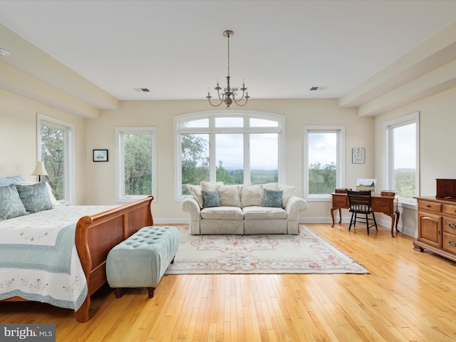 bedroom with a chandelier, light wood-style floors, multiple windows, and baseboards