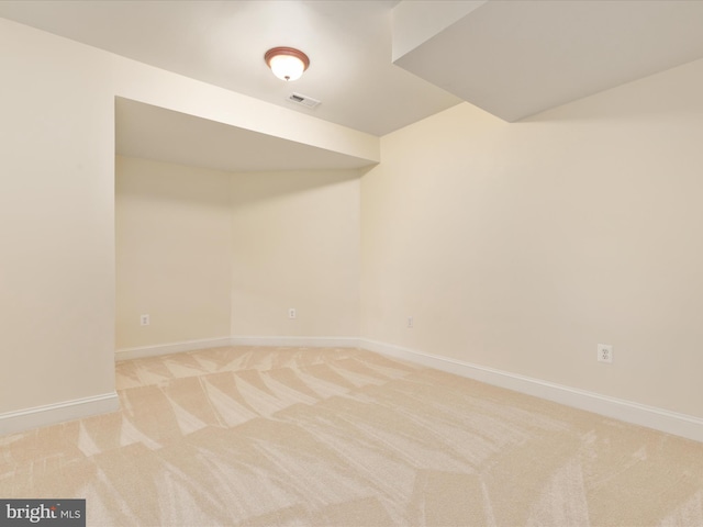 unfurnished room featuring light colored carpet and baseboards