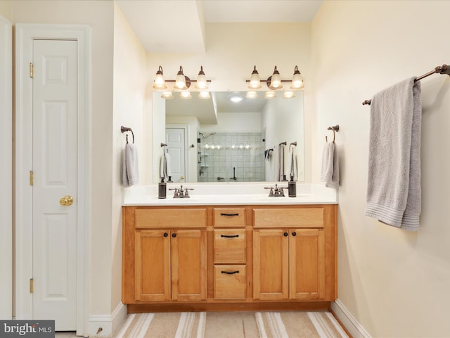 full bath featuring a shower stall, double vanity, and baseboards