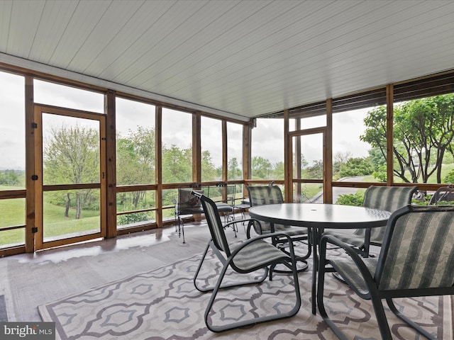 sunroom with outdoor dining space and carpet floors