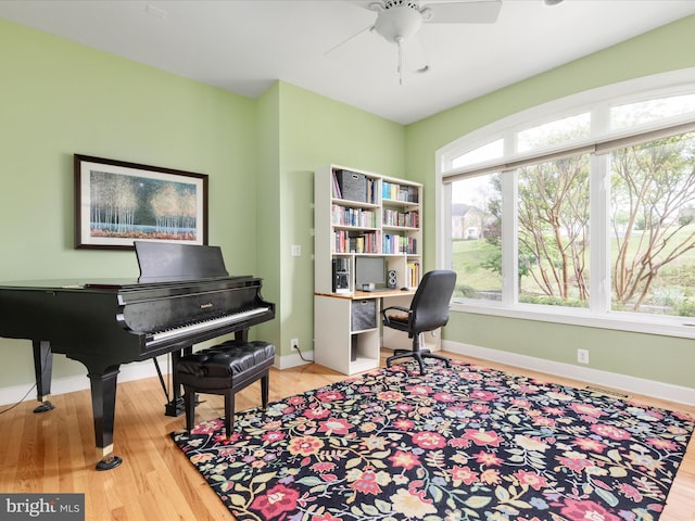 office featuring wood finished floors, a ceiling fan, and baseboards
