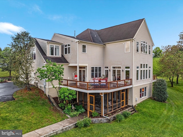 back of house with a deck, a sunroom, a lawn, and a shingled roof