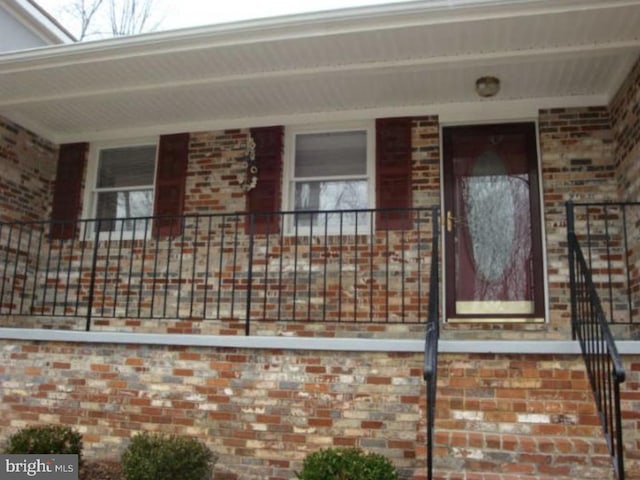 doorway to property with brick siding