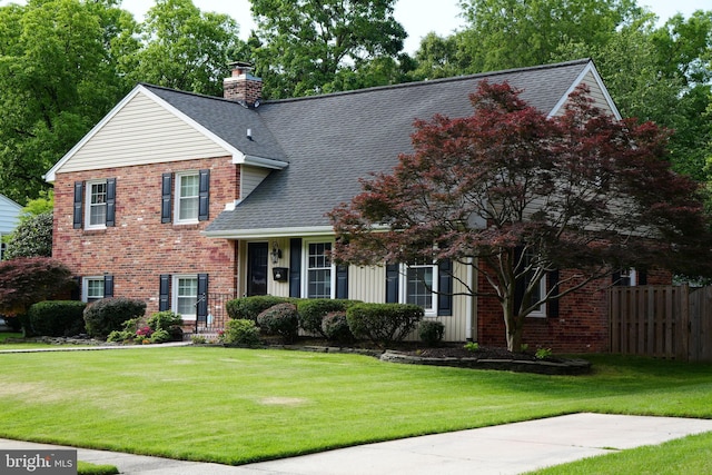 view of front facade featuring a shingled roof, a chimney, and brick siding