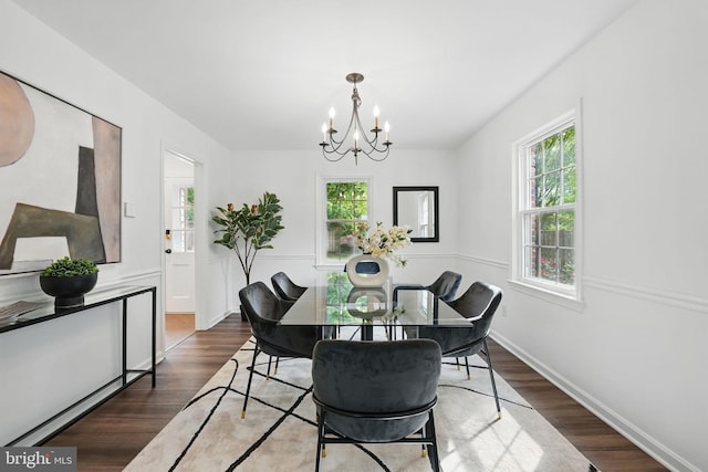dining space with a chandelier, wood finished floors, and baseboards