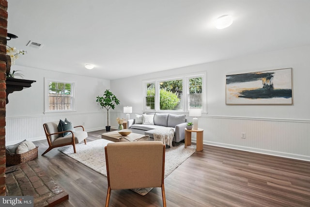 living area with a wainscoted wall and wood finished floors
