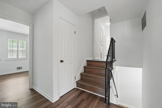 staircase featuring wood finished floors and baseboards