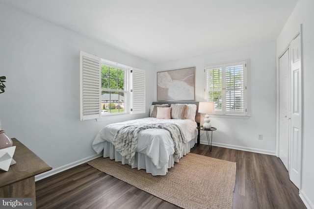 bedroom featuring wood finished floors, baseboards, and a closet