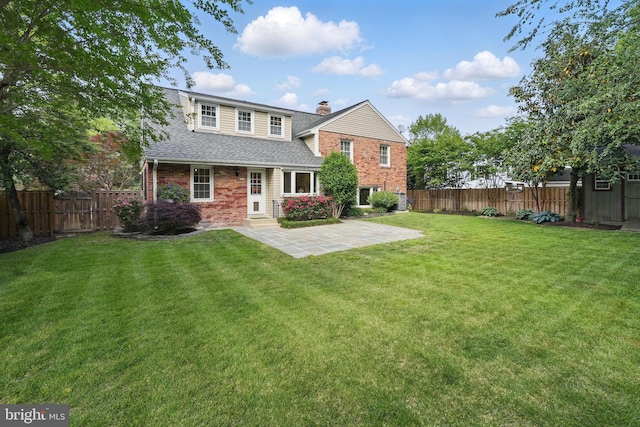 back of house with brick siding, roof with shingles, a chimney, a patio area, and entry steps