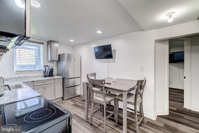 6328 Martin Luther King Jr Hwy, Capitol Heights, MD 20743 - kitchen with freestanding refrigerator, range with electric cooktop, light wood-style flooring, light stone counters, and a sink