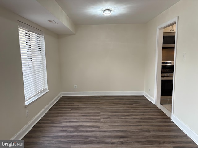 unfurnished room featuring dark wood finished floors and baseboards