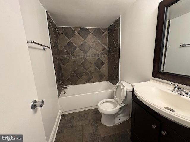 full bathroom with baseboards, toilet, vanity, shower / bath combination, and stone finish floors