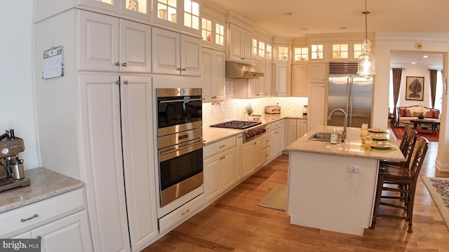 16 Magpie Ln, Princeton Junction, NJ 08550 - kitchen featuring stainless steel appliances, under cabinet range hood, decorative light fixtures, decorative backsplash, and a breakfast bar area
