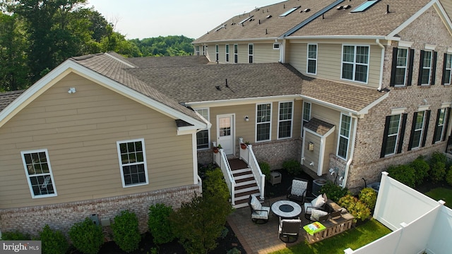 16 Magpie Ln, Princeton Junction, NJ 08550 - back of house featuring brick siding, an outdoor fire pit, a shingled roof, and a patio