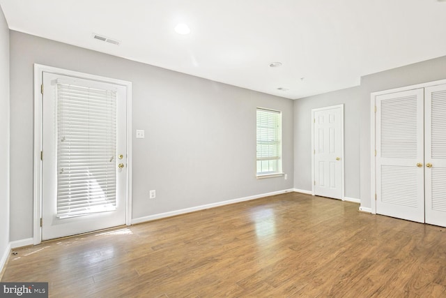 unfurnished bedroom featuring wood finished floors, baseboards, and recessed lighting