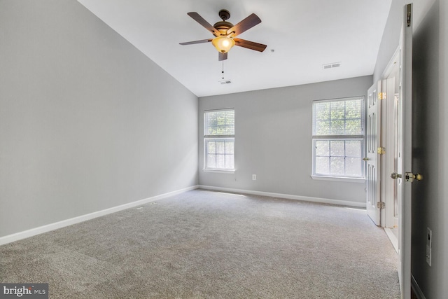 empty room featuring healthy amount of natural light, carpet floors, baseboards, and lofted ceiling