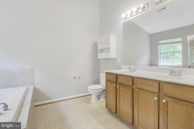full bathroom with baseboards, tiled tub, double vanity, tile patterned floors, and toilet