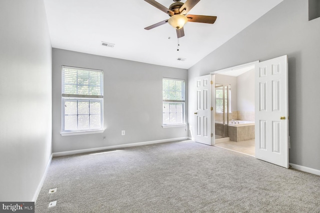 unfurnished bedroom featuring carpet flooring, baseboards, multiple windows, and vaulted ceiling