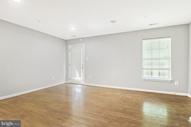 empty room featuring baseboards, wood finished floors, and recessed lighting