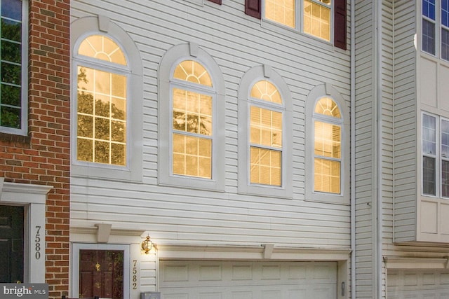 view of side of property featuring a garage and brick siding