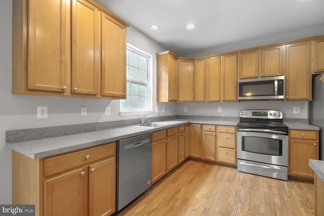 kitchen featuring appliances with stainless steel finishes, light wood-style floors, recessed lighting, and a sink