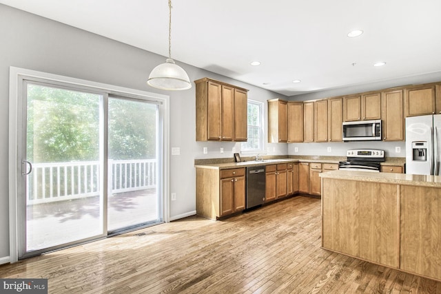 kitchen with stainless steel appliances, light countertops, light wood-style floors, pendant lighting, and recessed lighting