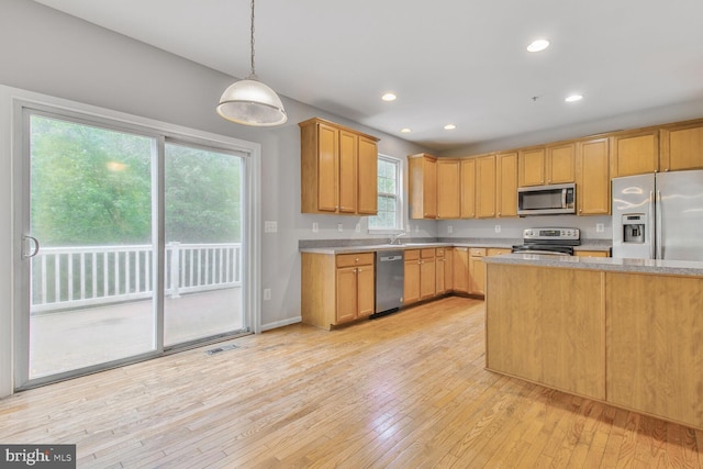 kitchen featuring stainless steel appliances, light countertops, light wood-style flooring, decorative light fixtures, and recessed lighting