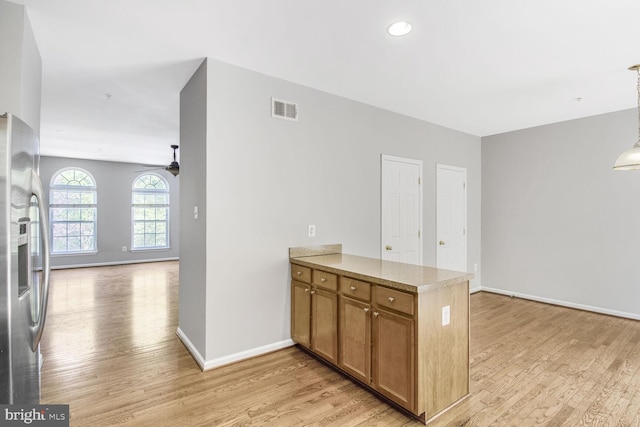kitchen with light wood finished floors, open floor plan, stainless steel fridge with ice dispenser, a peninsula, and recessed lighting