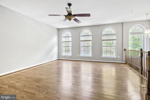 spare room featuring plenty of natural light, hardwood / wood-style floors, and baseboards