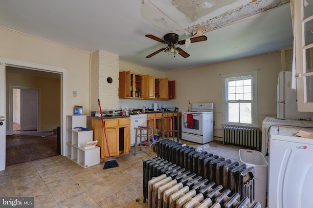 kitchen featuring white appliances, washer / clothes dryer, radiator, and brown cabinets