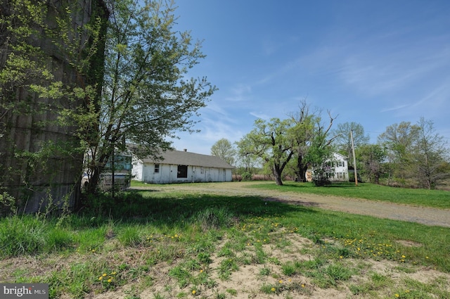 view of yard featuring dirt driveway