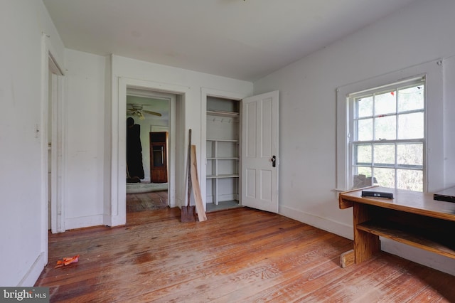 bedroom with light wood-type flooring, baseboards, and a closet