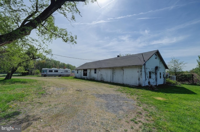 view of home's exterior with a yard and dirt driveway