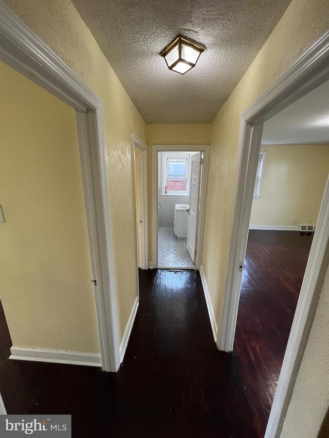 1128 Elbridge St, Philadelphia, PA 19111 - hallway featuring wood finished floors, a textured wall, a textured ceiling, and baseboards