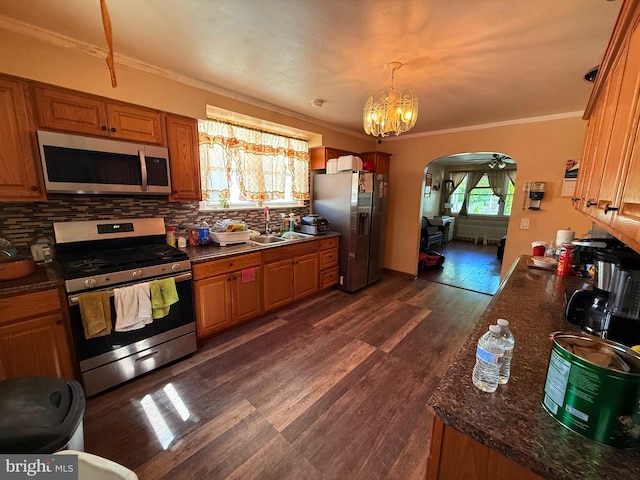 418 N 8th St, Vineland, NJ 08360 - kitchen with appliances with stainless steel finishes, ornamental molding, arched walkways, backsplash, and dark wood-style flooring