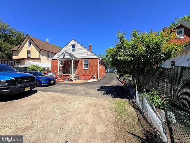 418 N 8th St, Vineland, NJ 08360 - view of front of property featuring brick siding, fence, and a chimney