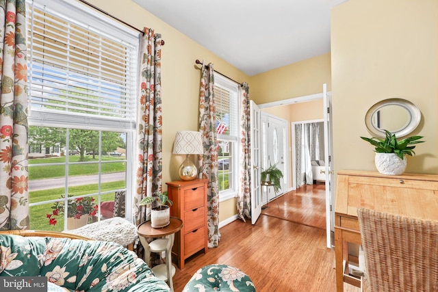 living area featuring light wood-style flooring, healthy amount of natural light, and baseboards