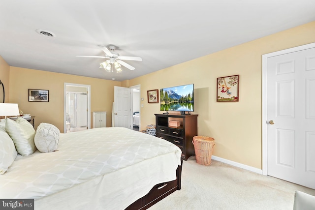 bedroom featuring light colored carpet, baseboards, ensuite bathroom, and a ceiling fan