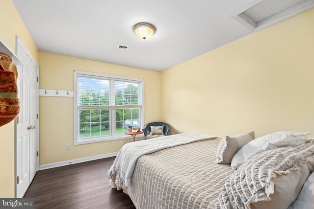 bedroom with attic access, wood finished floors, and baseboards