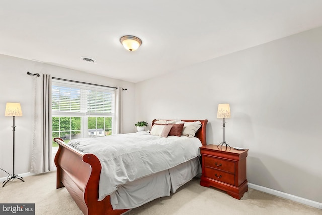 bedroom featuring light colored carpet and baseboards