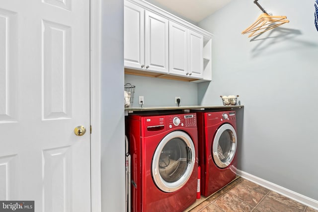 washroom with washing machine and dryer, cabinet space, and baseboards