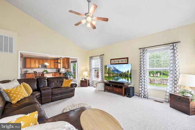 carpeted living room with ceiling fan, high vaulted ceiling, and baseboards