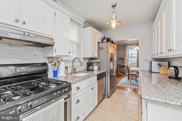 5100 Eugene Ave, Baltimore, MD 21206 - kitchen featuring stainless steel appliances, a sink, under cabinet range hood, white cabinetry, and backsplash